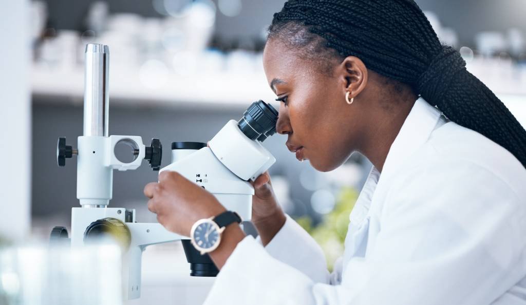 Healthcare Analytics - VLMS Healthcare Black woman, medical science and microscope in laboratory for research, analytics and medicine. Wom