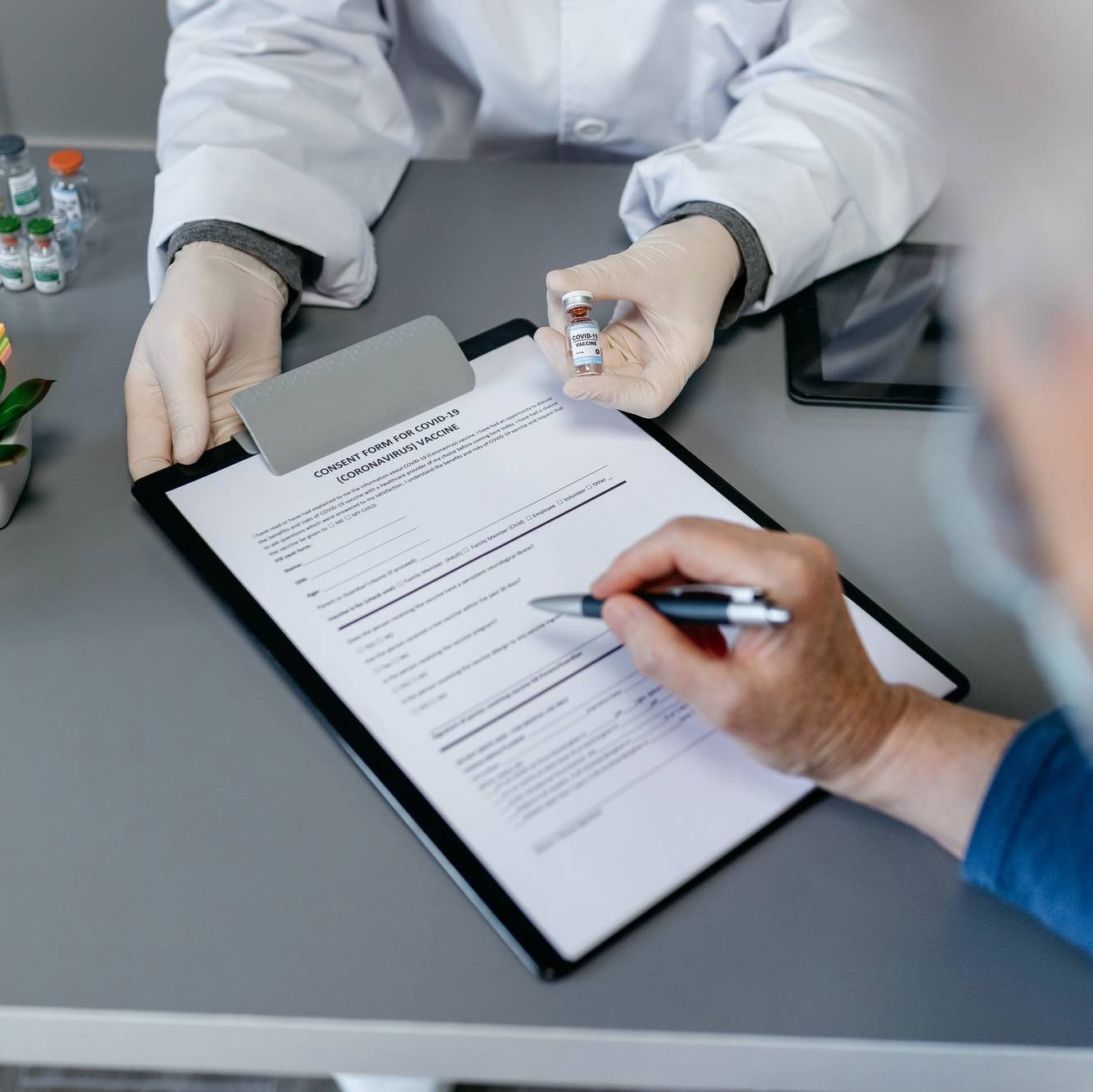 Risk Adjustment Services - VLMS Healthcare Doctor explaining to her patient the benefits and risks of the coronavirus vaccine